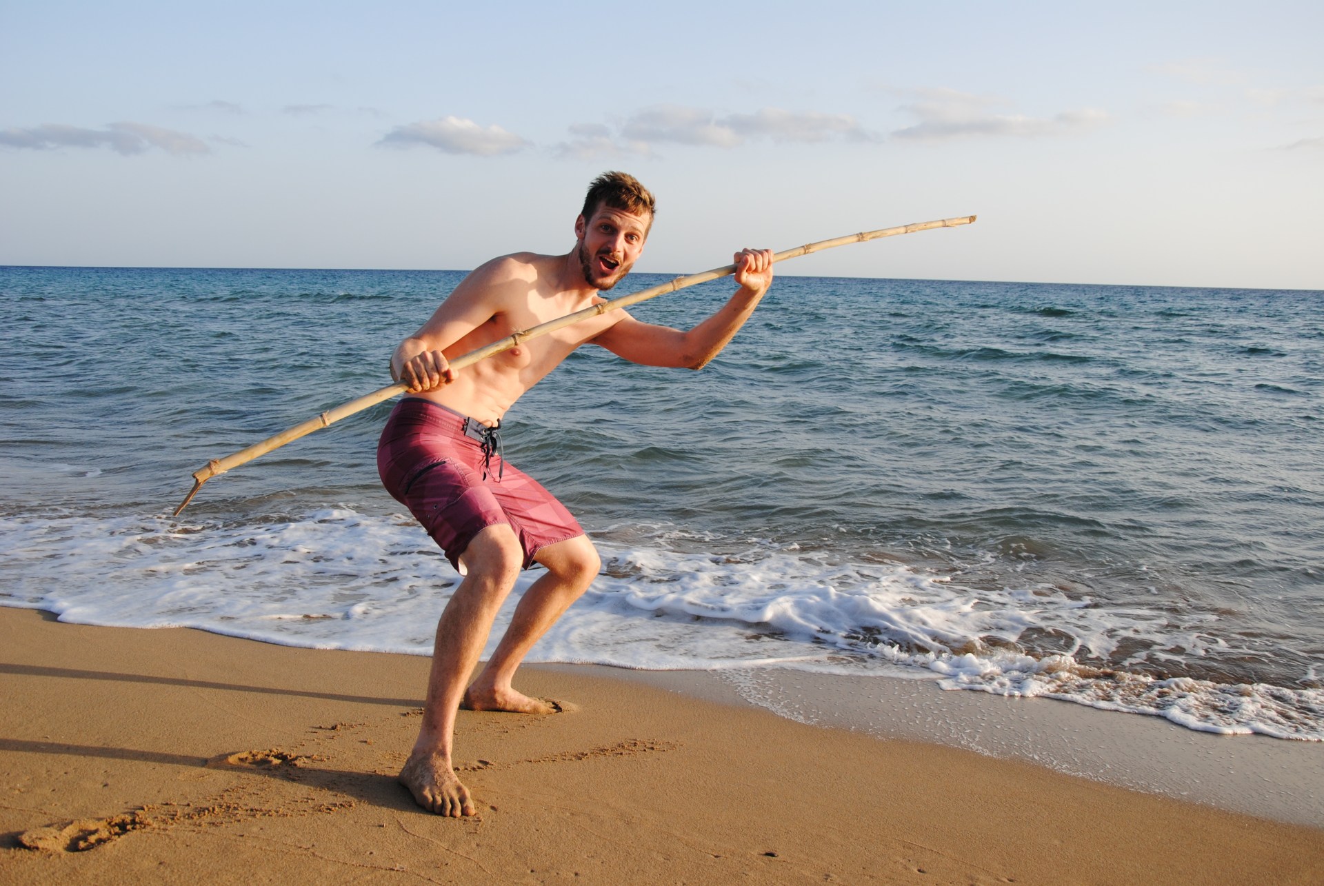 Sebastian steht am Strand und hat einen langen Stock in der Hand