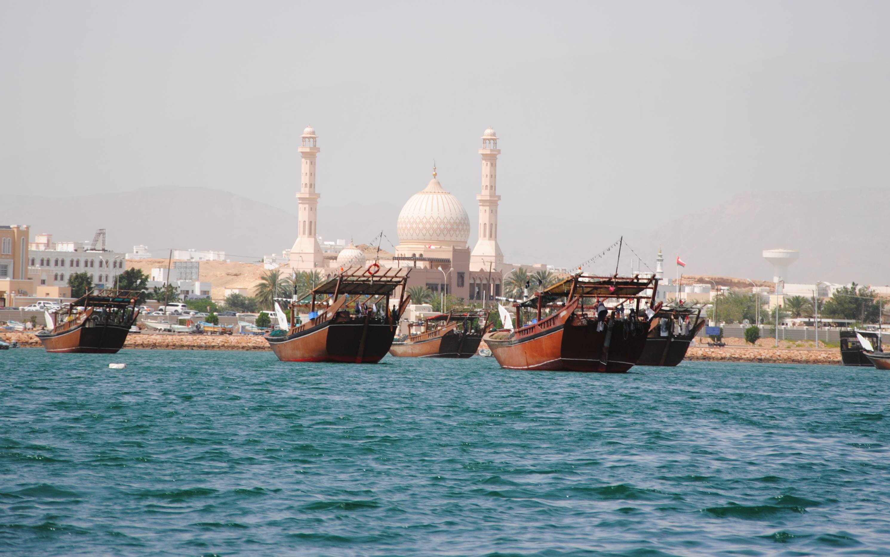 Dhaus im Hafen und eine Moschee im Hintergrund
