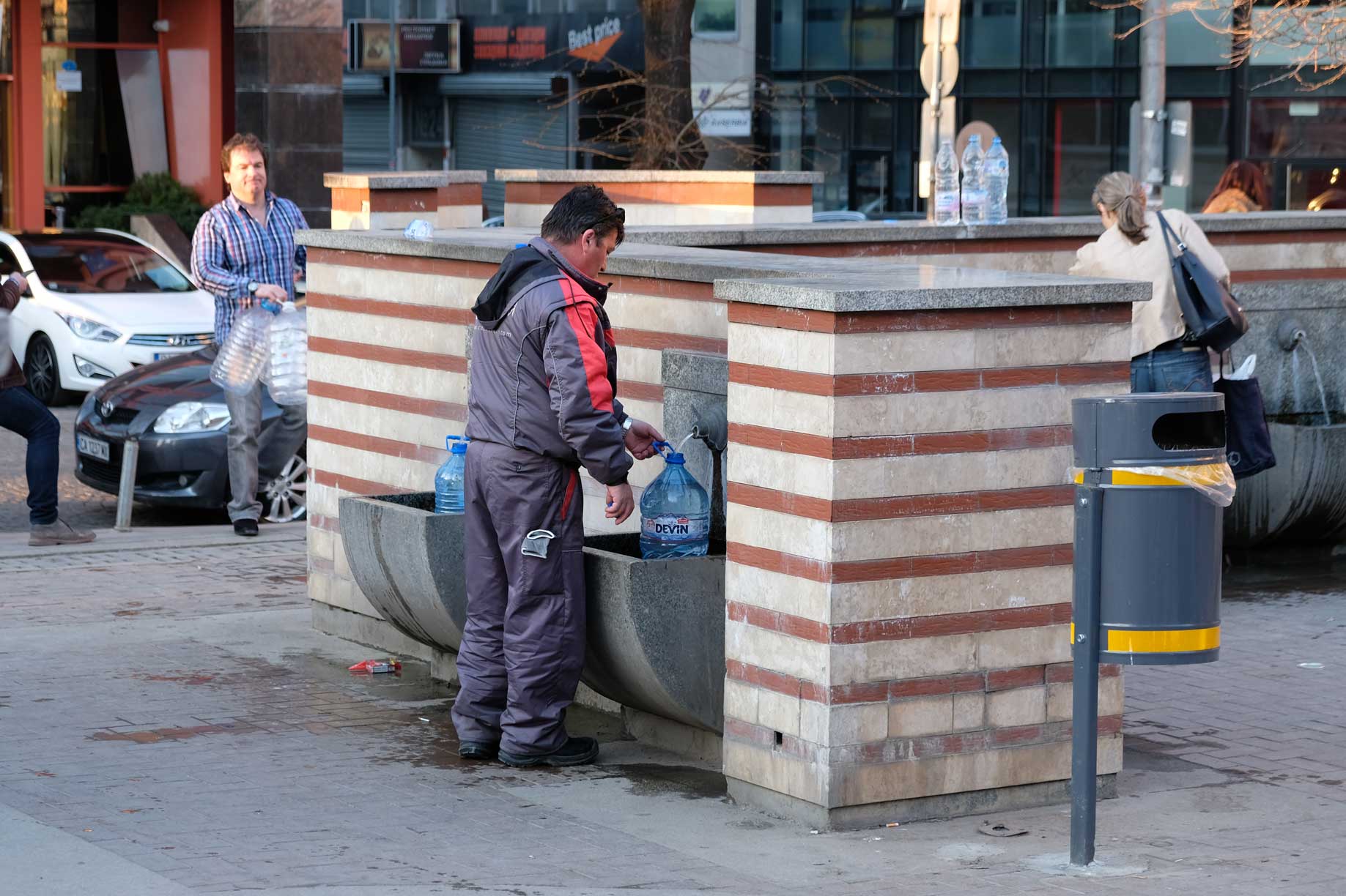 Ein Mann füllt Brunnenwasser in einen Kanister