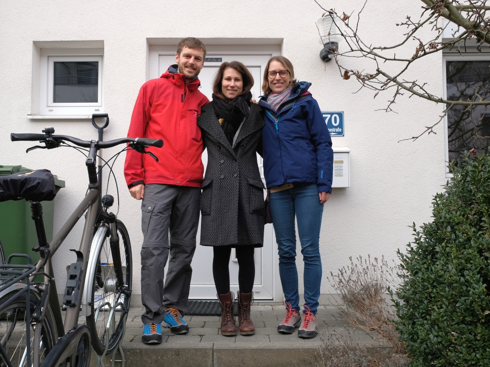 Sebastian, Jana und Leo stehen vor einem Haus