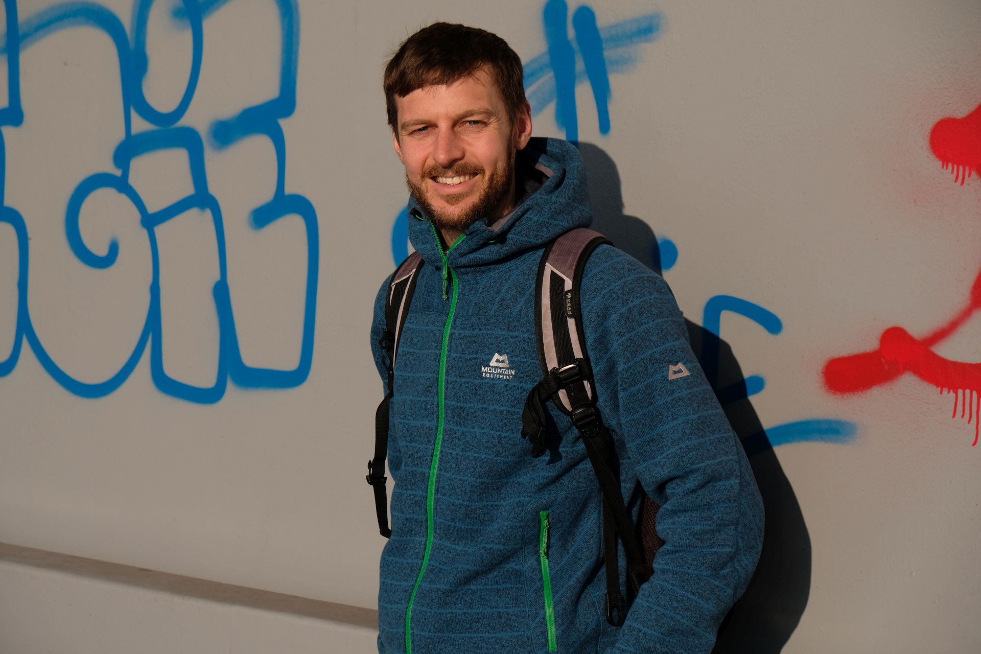 Sebastian vor einer mit Graffiti besprühten Mauer