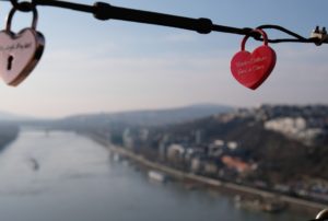 Zwei Schlösser in Herzform, im Hintergund die Donau