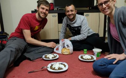 Sebastian und Leo sitzen mit Fatih auf dem Boden und essen