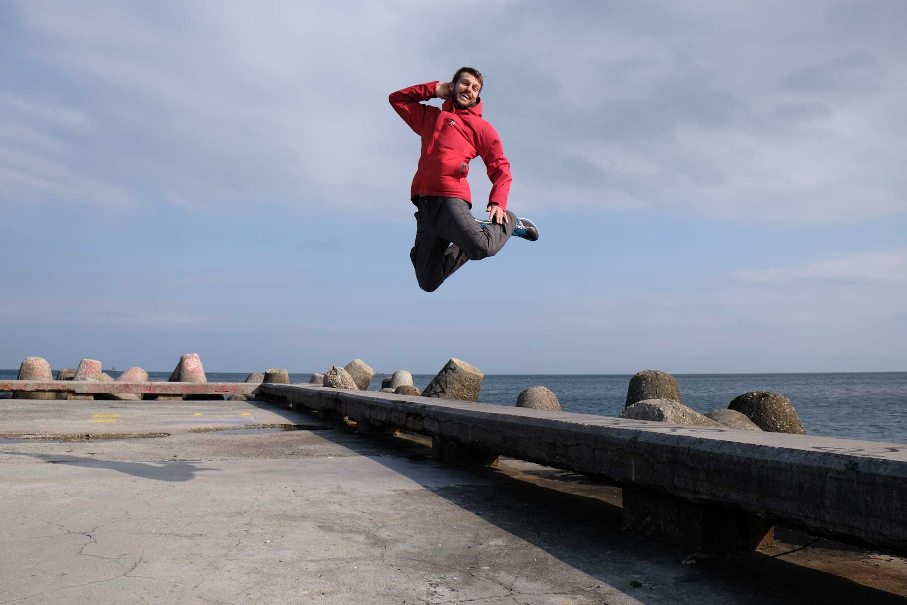 Sebastian springt von einer Steinbank am Meer