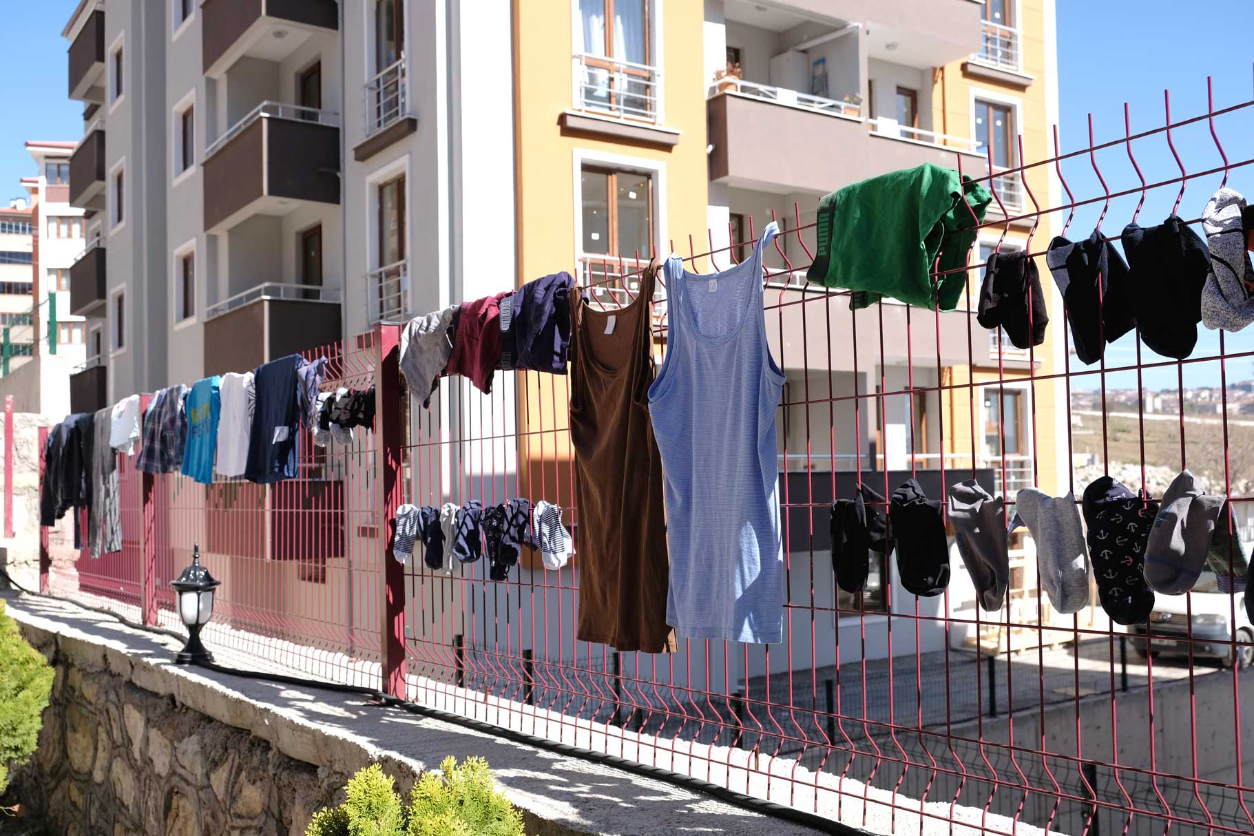 Wäsche hängt zum Trocknen an einem Zaun