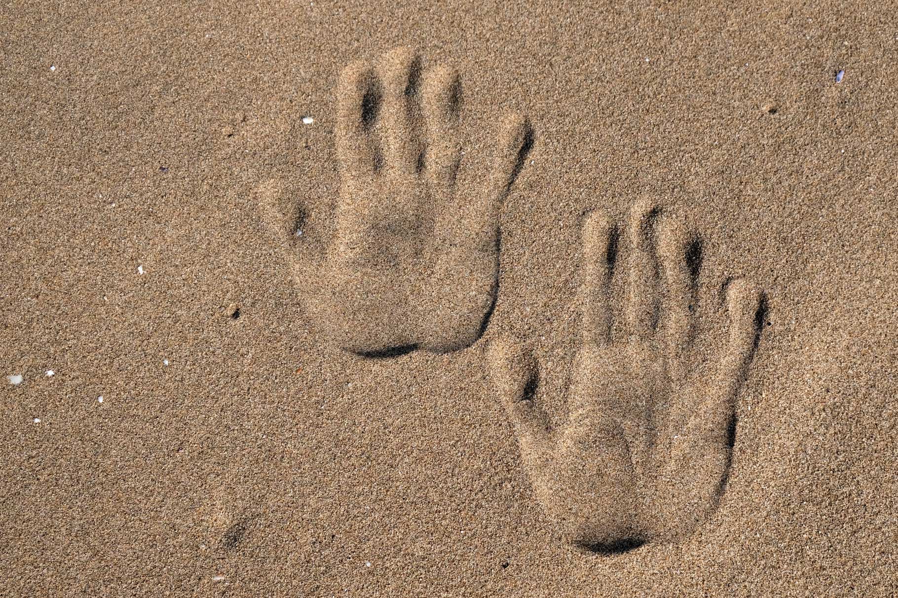 Zwei Handabdrücke im Sand