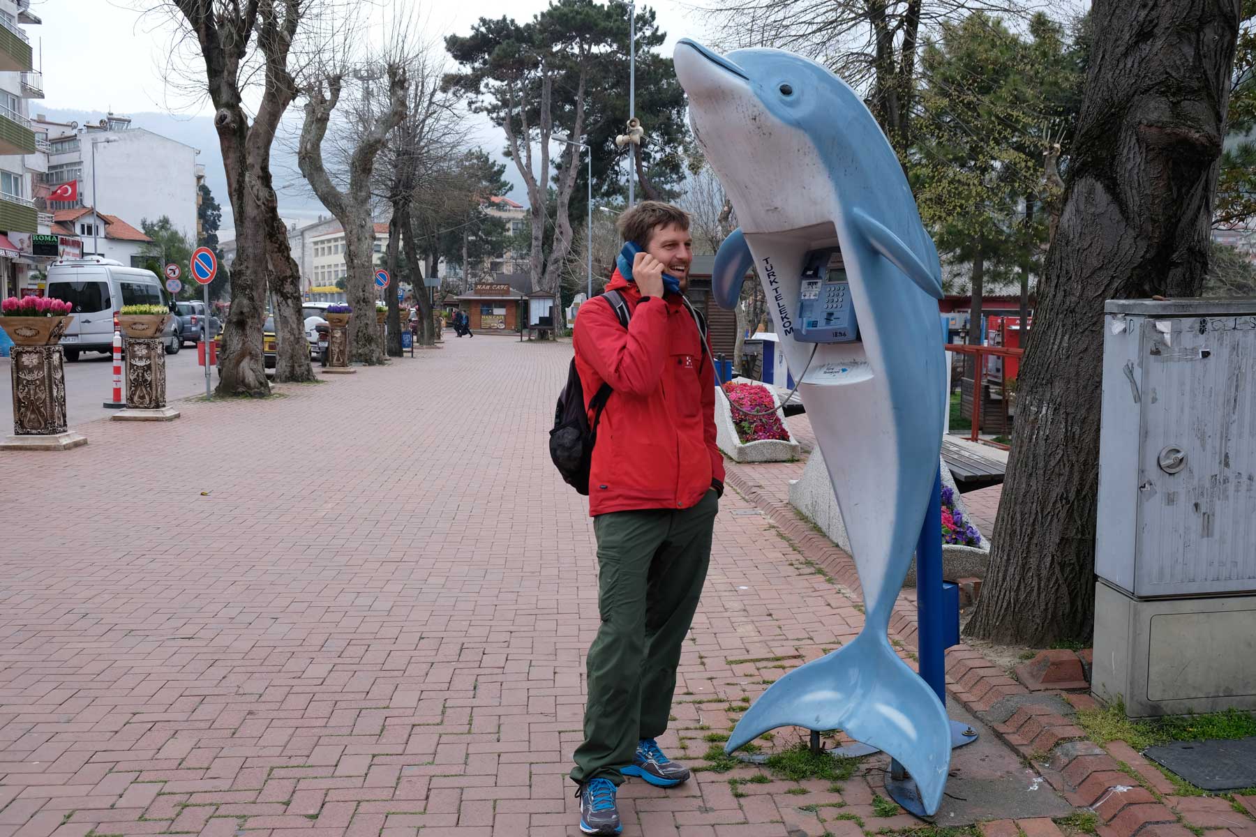 Sebastian telefoniert an einer Telefonzelle in Delfinform