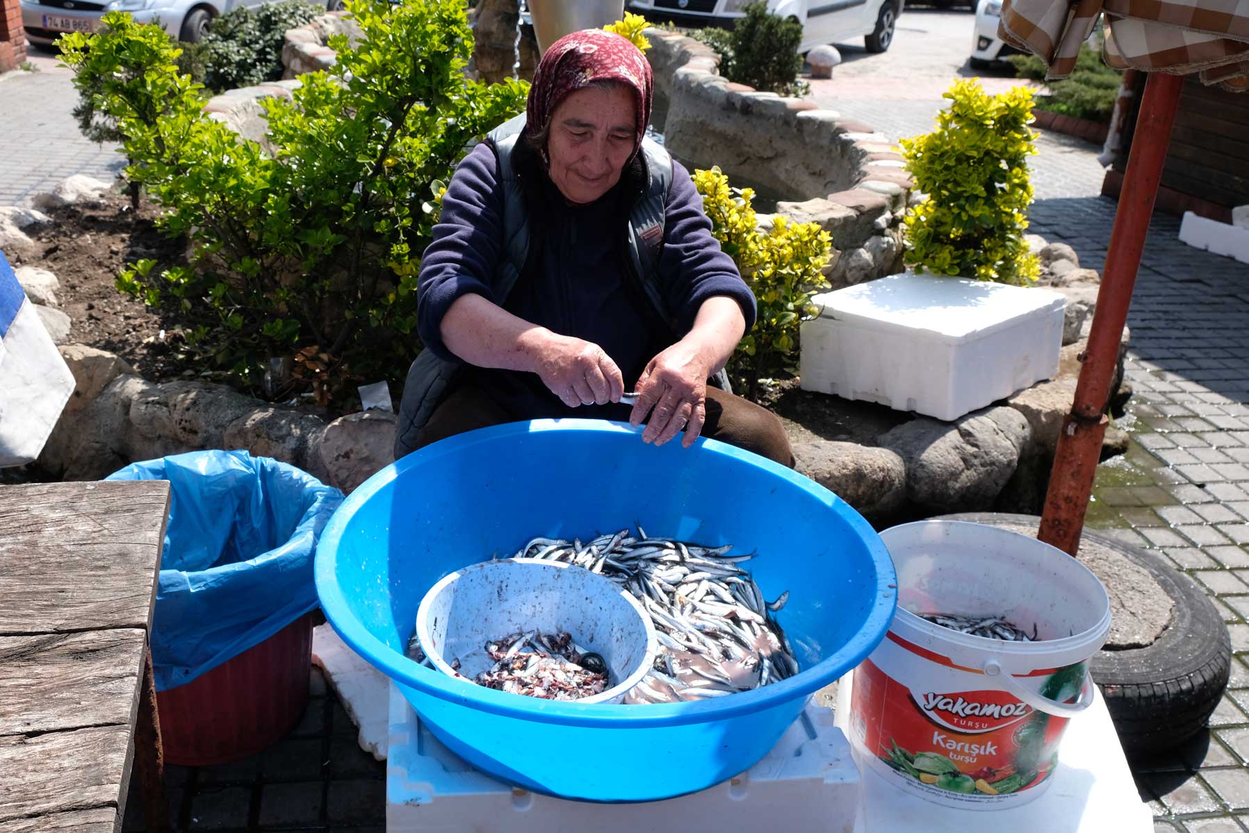 Eine Frau nimmt kleine Fische aus