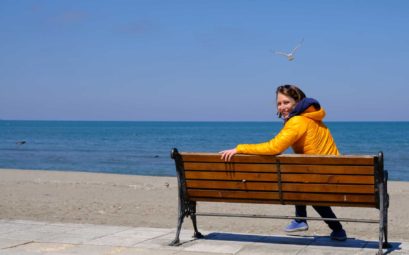 Leo sitzt auf einer Bank am Meer