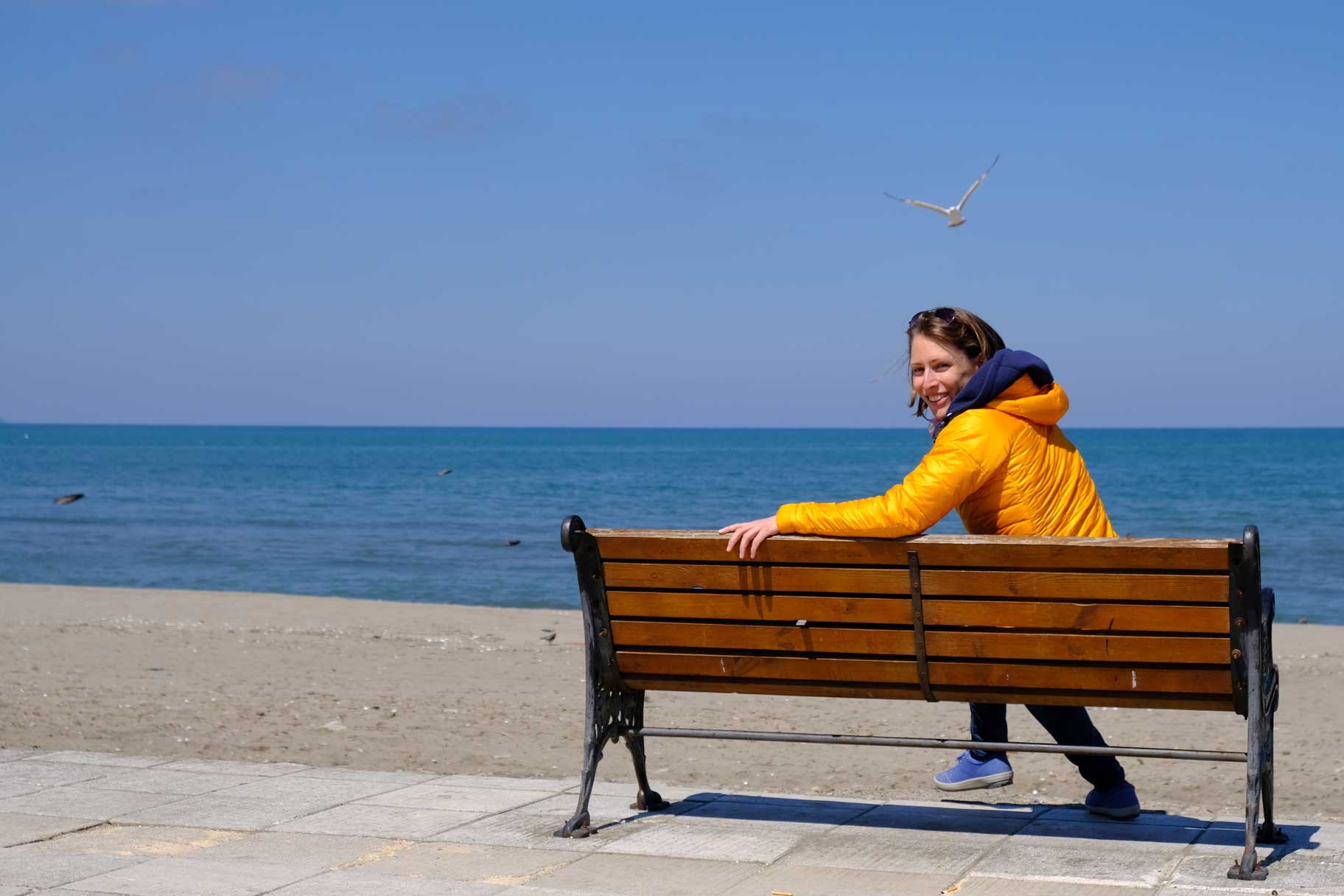 Leo sitzt auf einer Bank am Meer