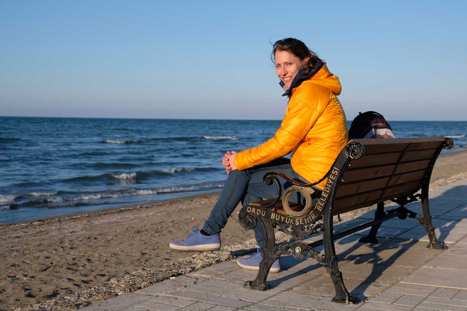 Leo sitzt auf einer Bank am Strand