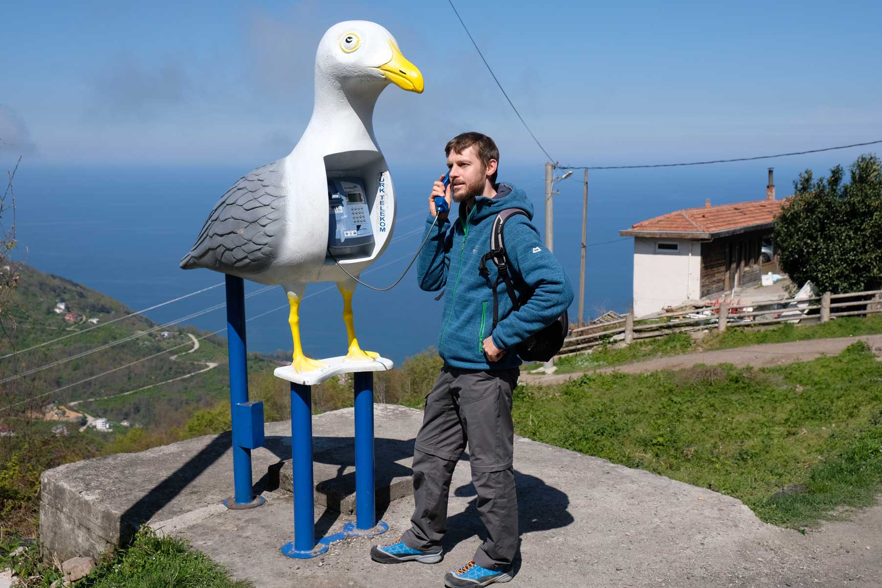 Sebastian telefoniert an einer Telefonzelle in Möwenform