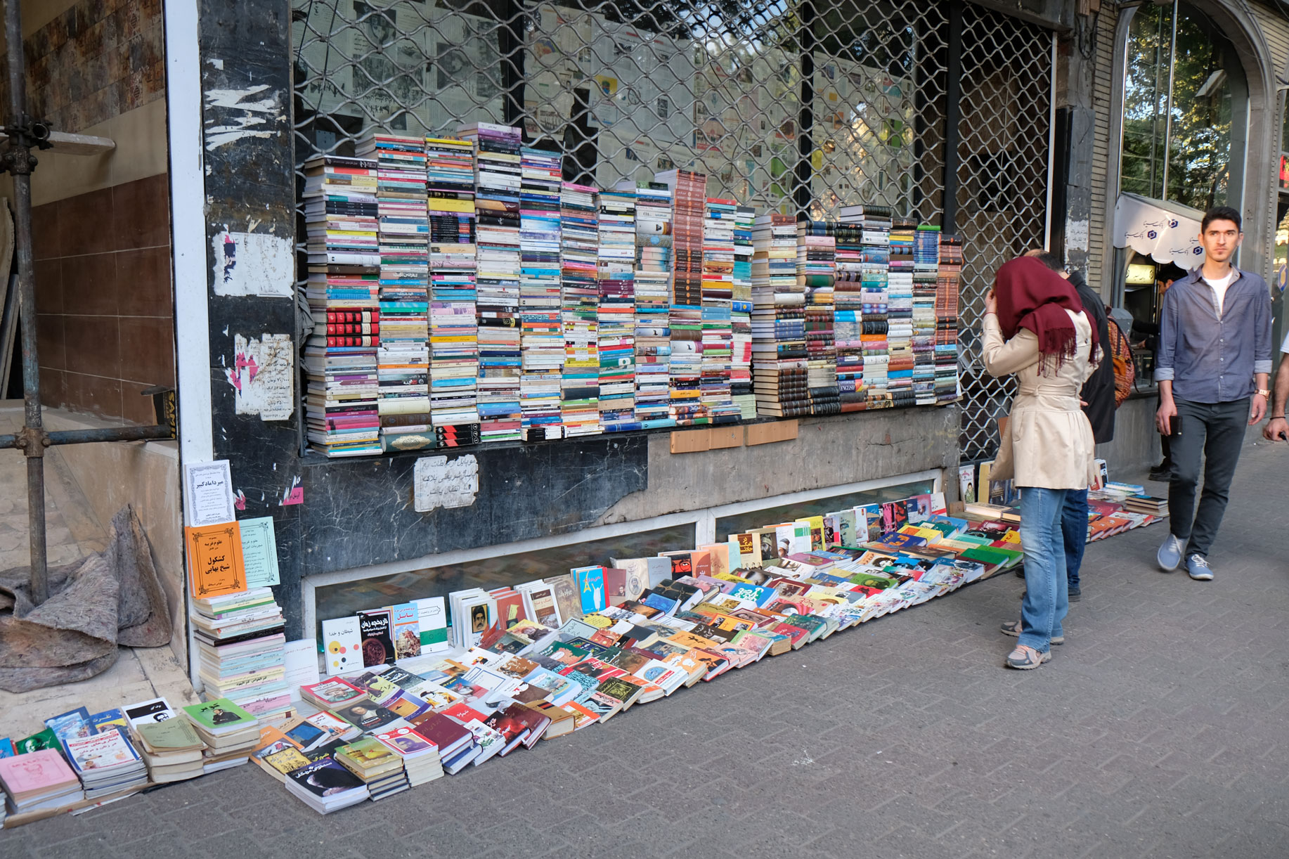 Vor einem geschlossenen Geschäft sind viele Bücher zu Stapeln angeordnet