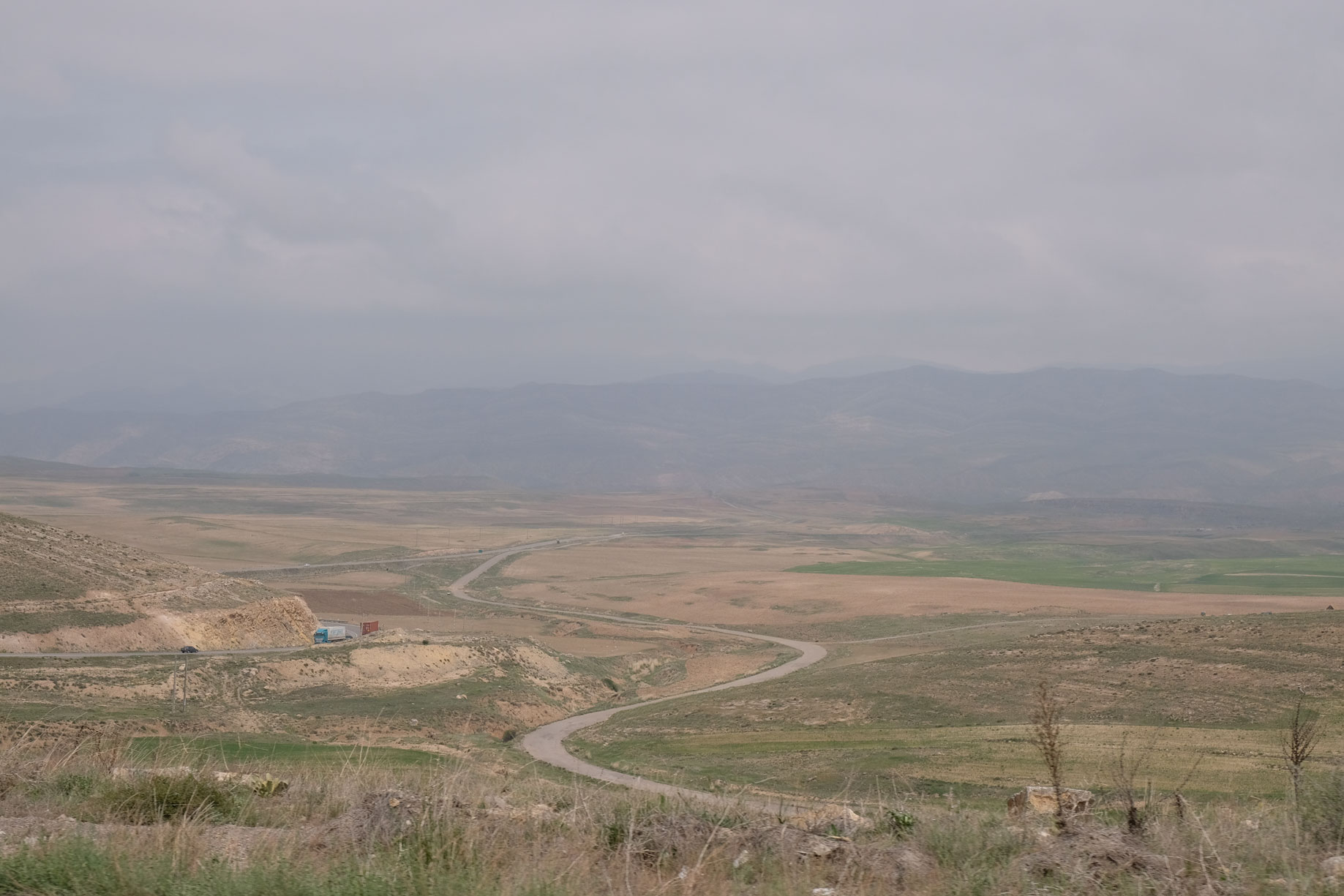 Kurvige Straße in nebliger Landschaft