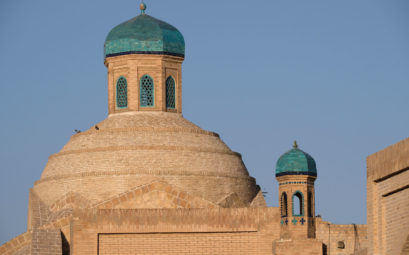 Sandsteinfarbene Gebäude mit türkisfarbenen Kuppeln