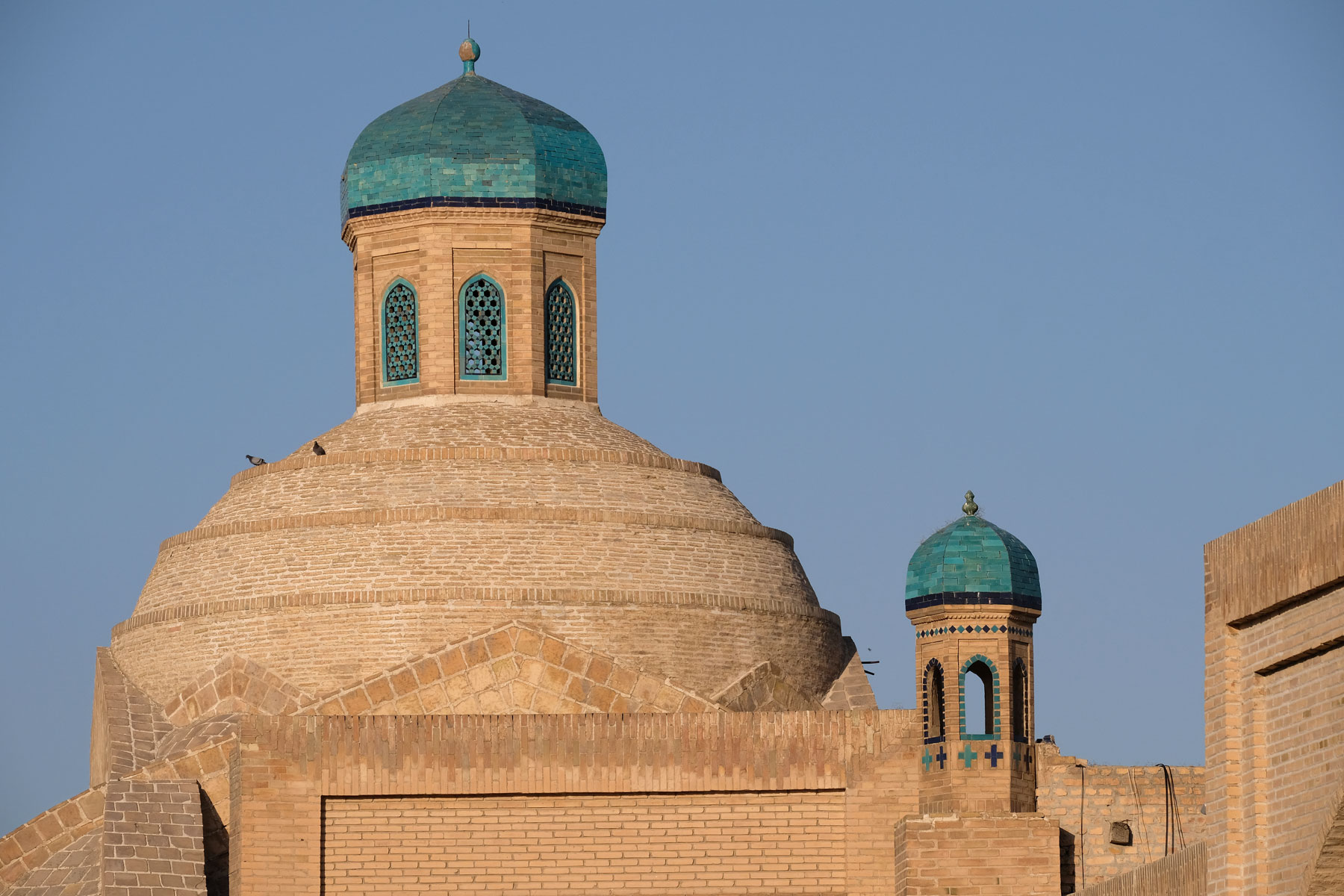 Sandsteinfarbene Gebäude mit türkisfarbenen Kuppeln