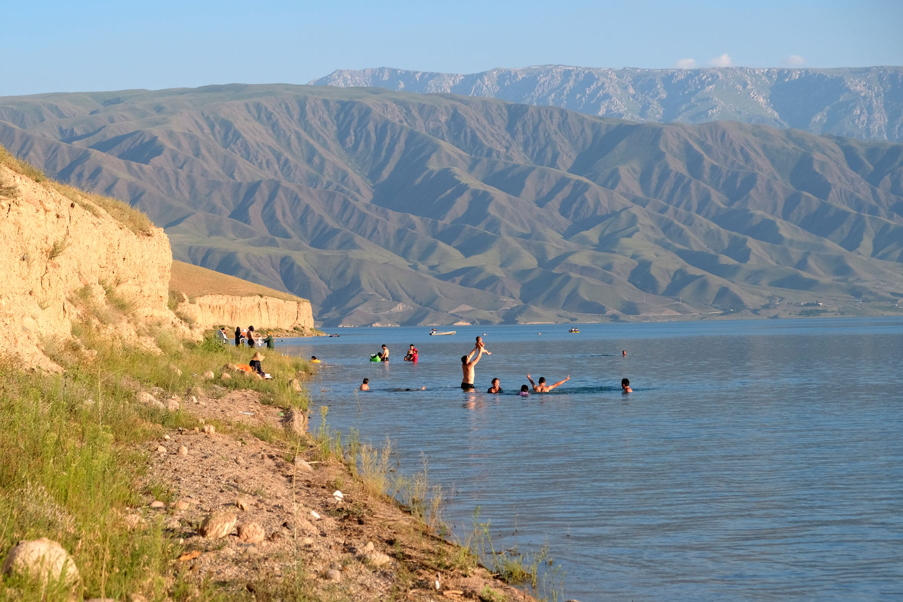 Menschen baden im Toktogul-See in Kirgistan