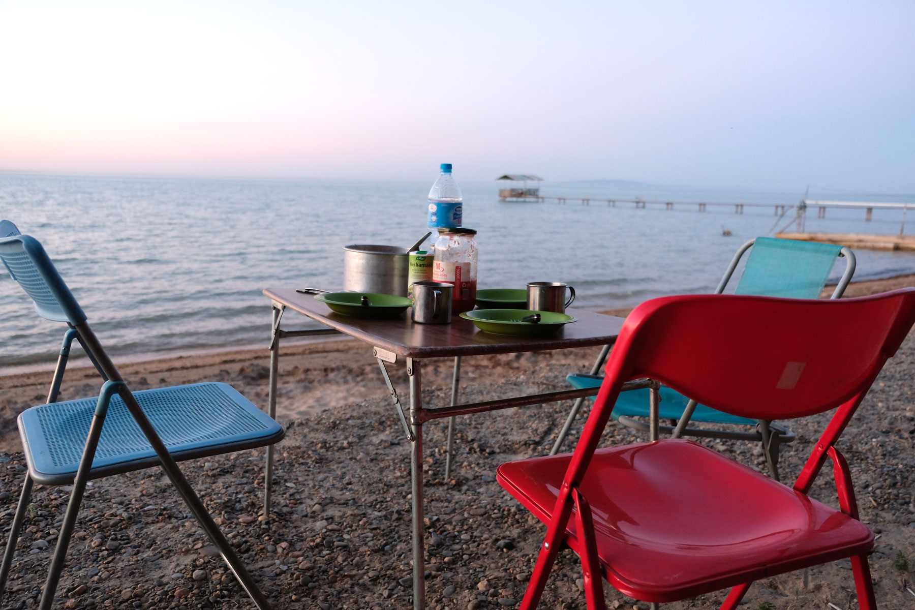 Campingstühle und ein Campingtisch am Ufer des Tudakul-Sees