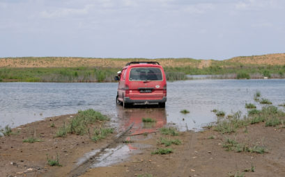Ein roter Kleintransporter steckt in einem See fest