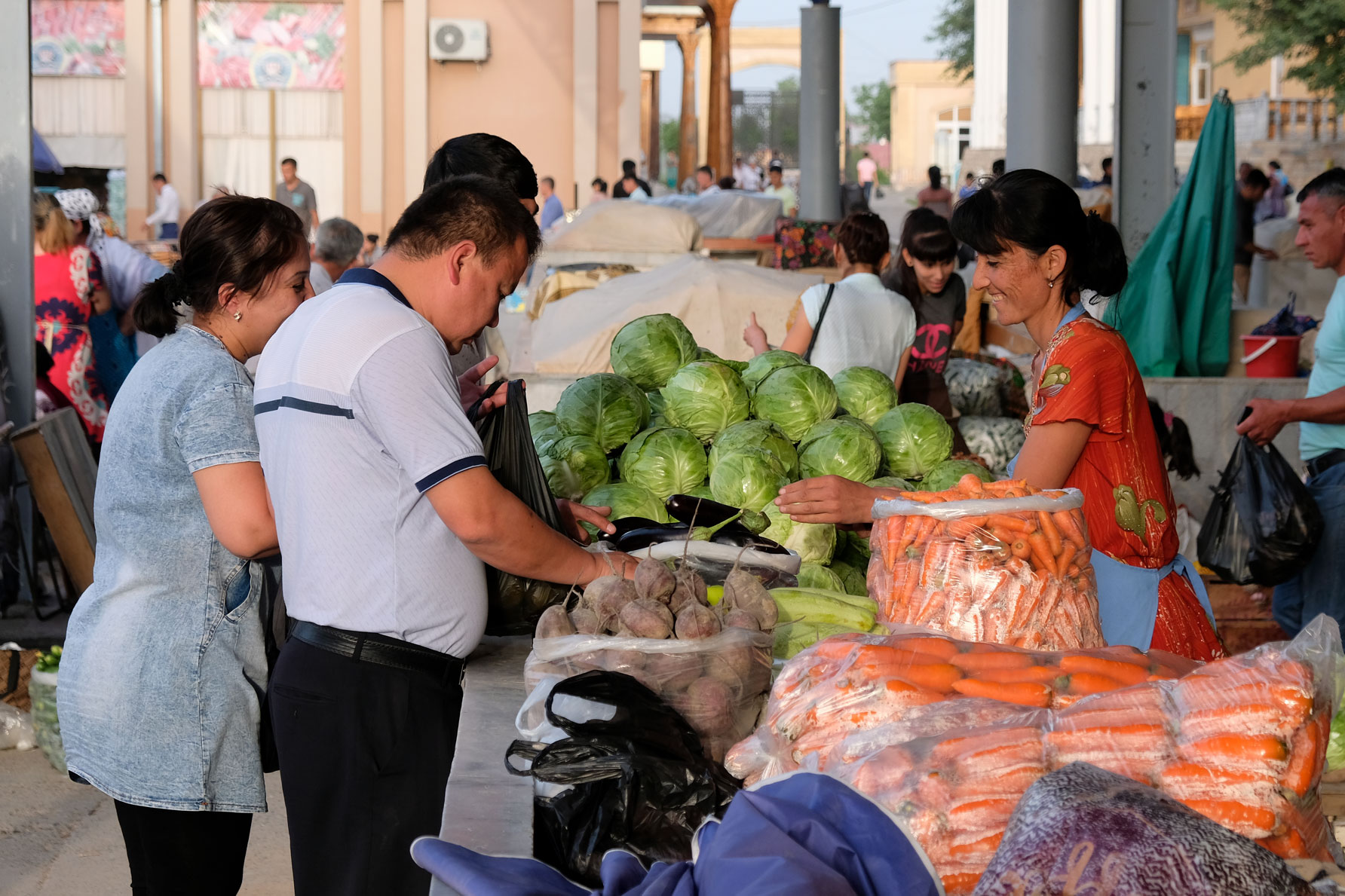 Menschen an einem Marktstand, an derm Kohl verkauft wird