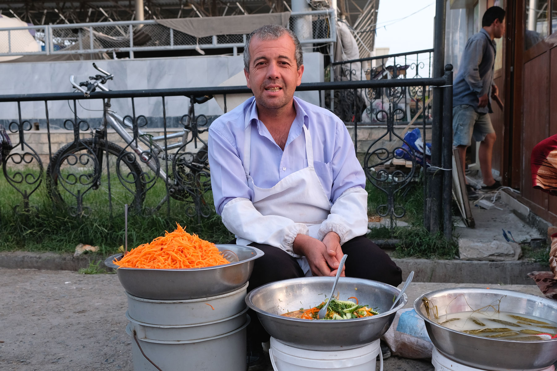 Ein Mann verkauft Salat auf dem Basar von Samarkand