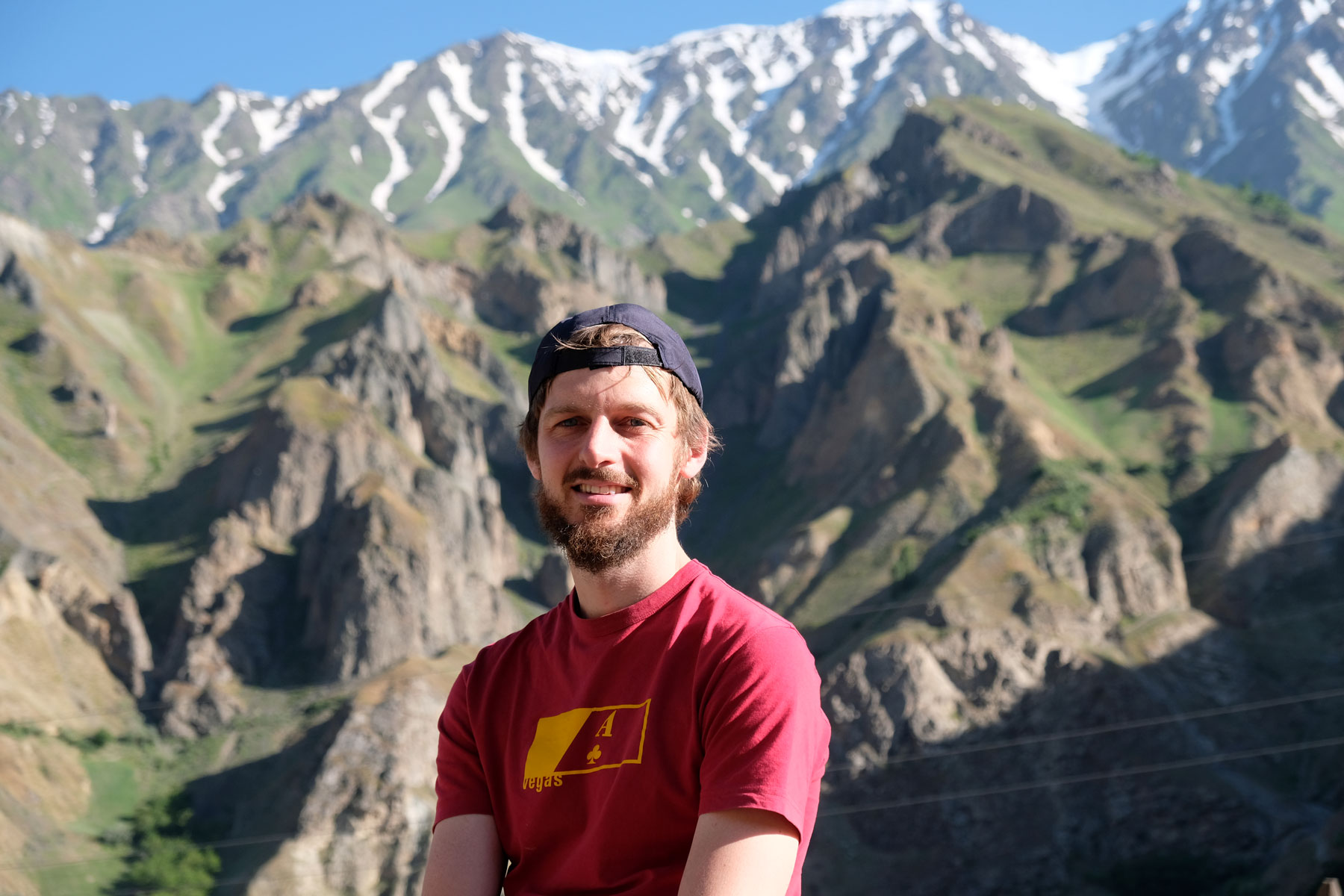 Sebastian vor schneebedeckten Bergen.