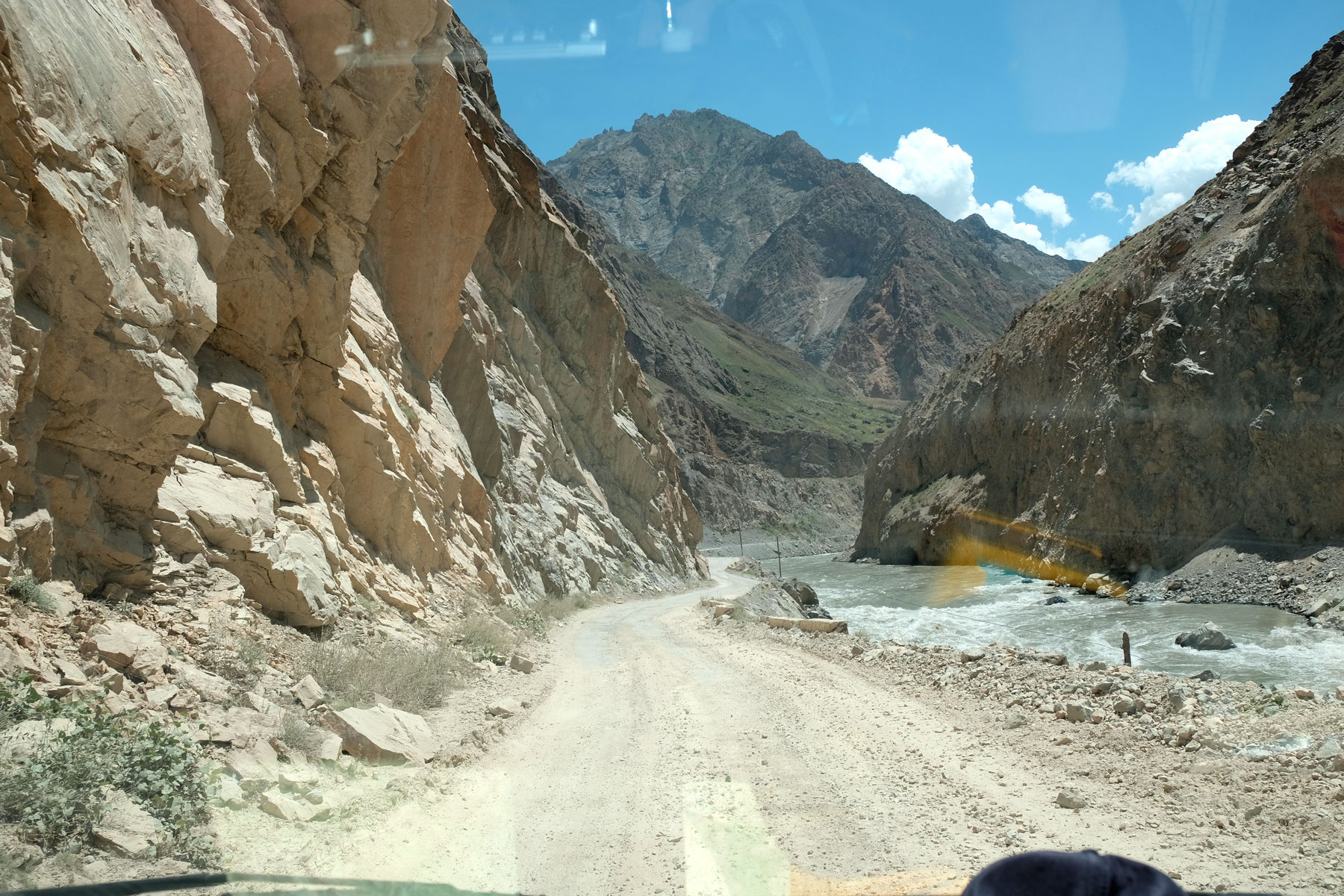 Schotterstraße neben einem Fluss auf dem Pamir Highway in Tadschikistan