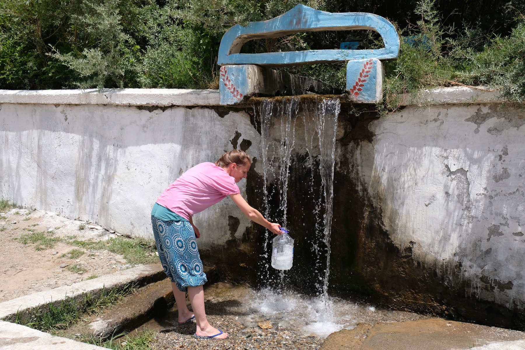 Leo füllt Quellwasser in einen Kanister.