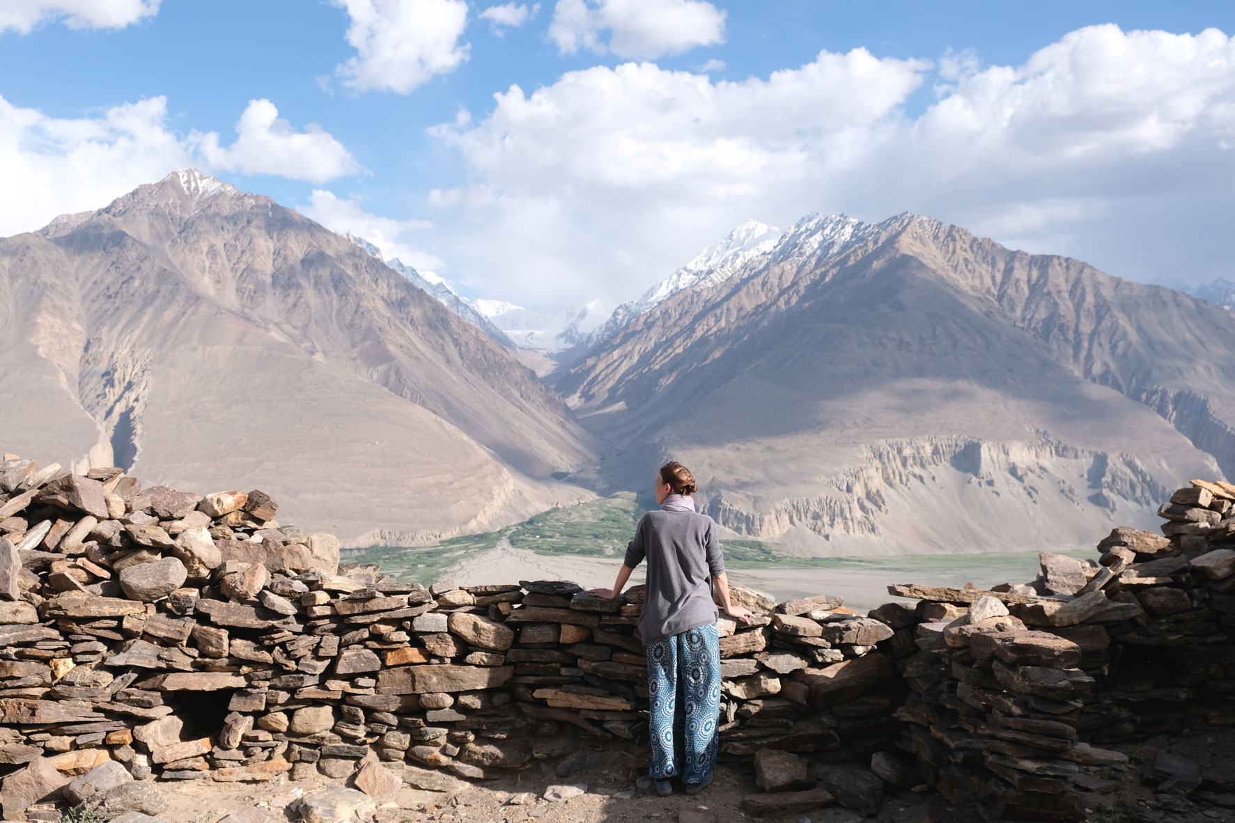 Leo blickt von einer Mauer des Yamchun Forts auf das Pamirgebirge in Afghanistan.