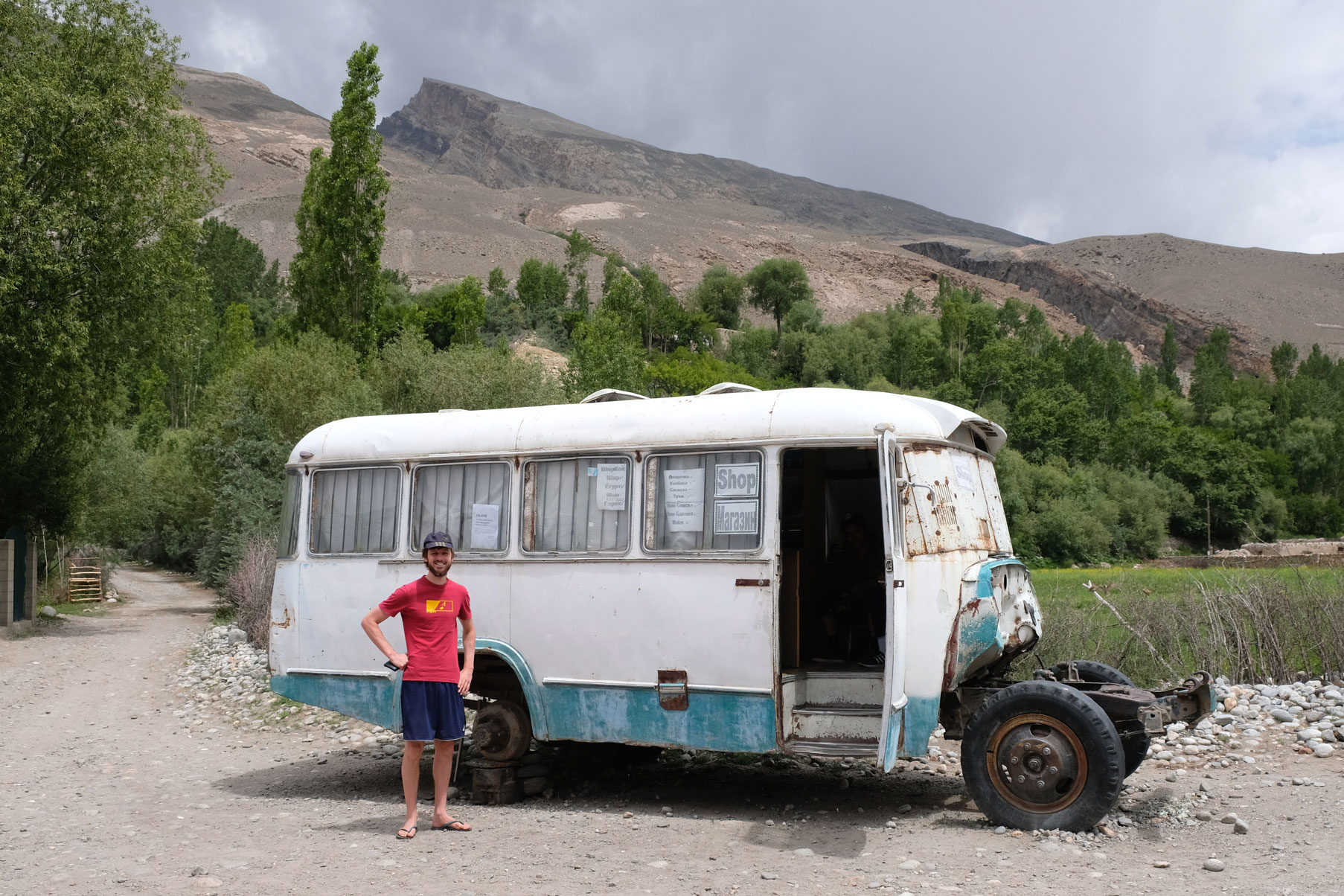 Sebastian steht neben einem Bus, auf dem geschrieben steht, dass sich darin ein Geschäft befindet.