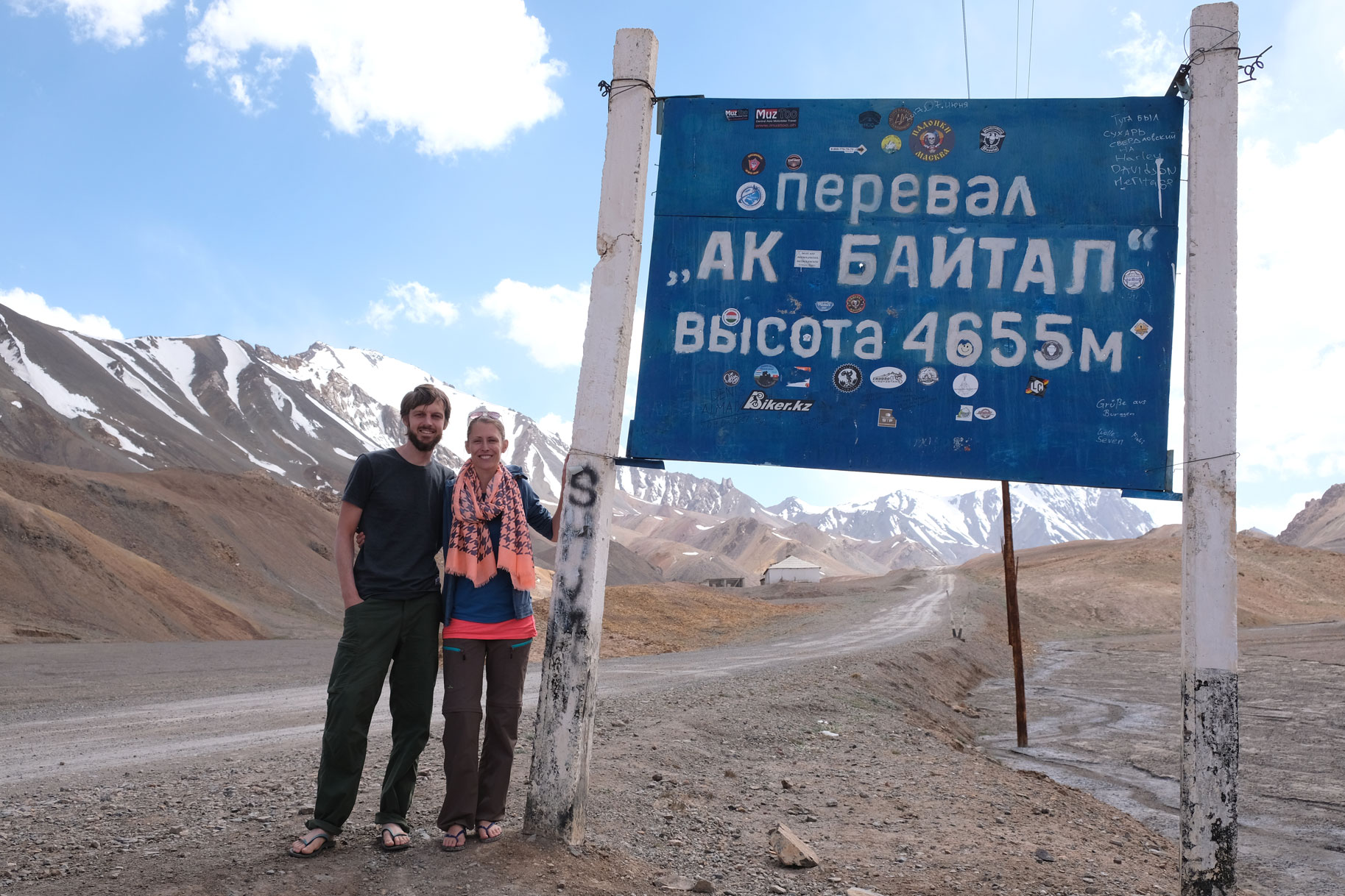 Sebastian und Leo neben einem Schild, auf dem "Ak Baital 4655 Meter" steht.