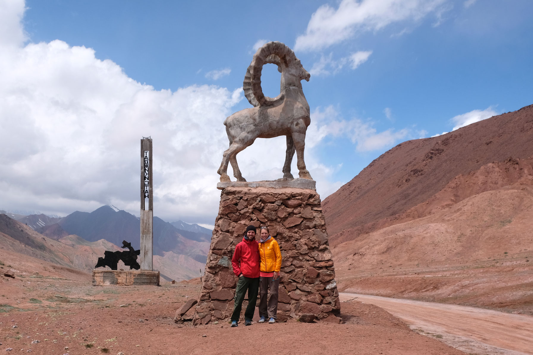 Sebastian und Leo vor einer Statue eines Steinbocks.