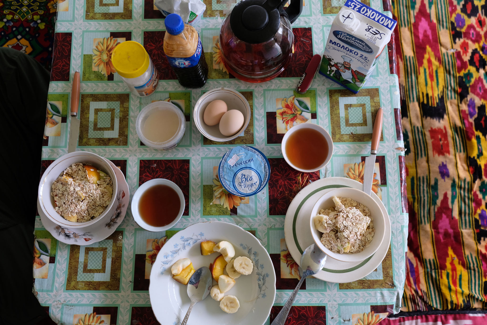 Frühstückstisch mit Eiern, Müsli, Obst und Tee.