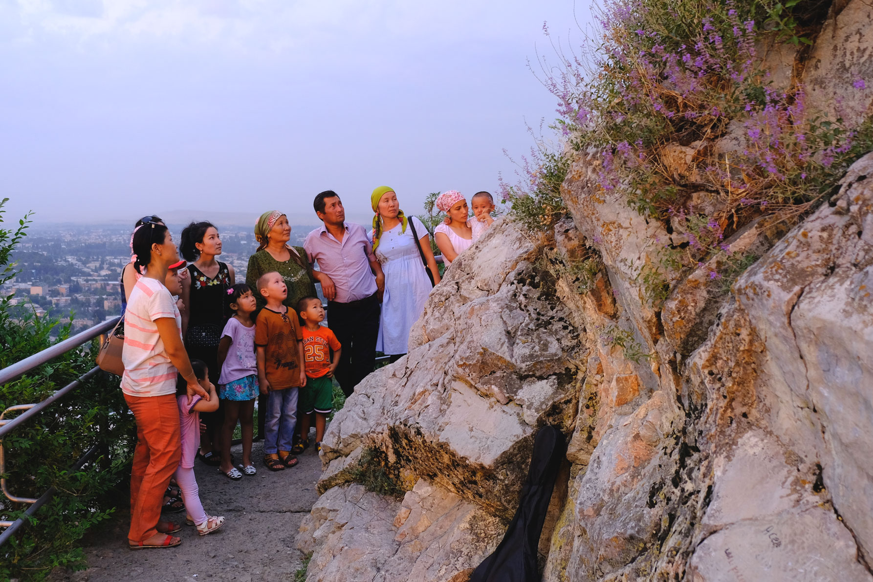 Eine kirgisische Familie schaut auf einen Felsen am Sulaiman-Too.