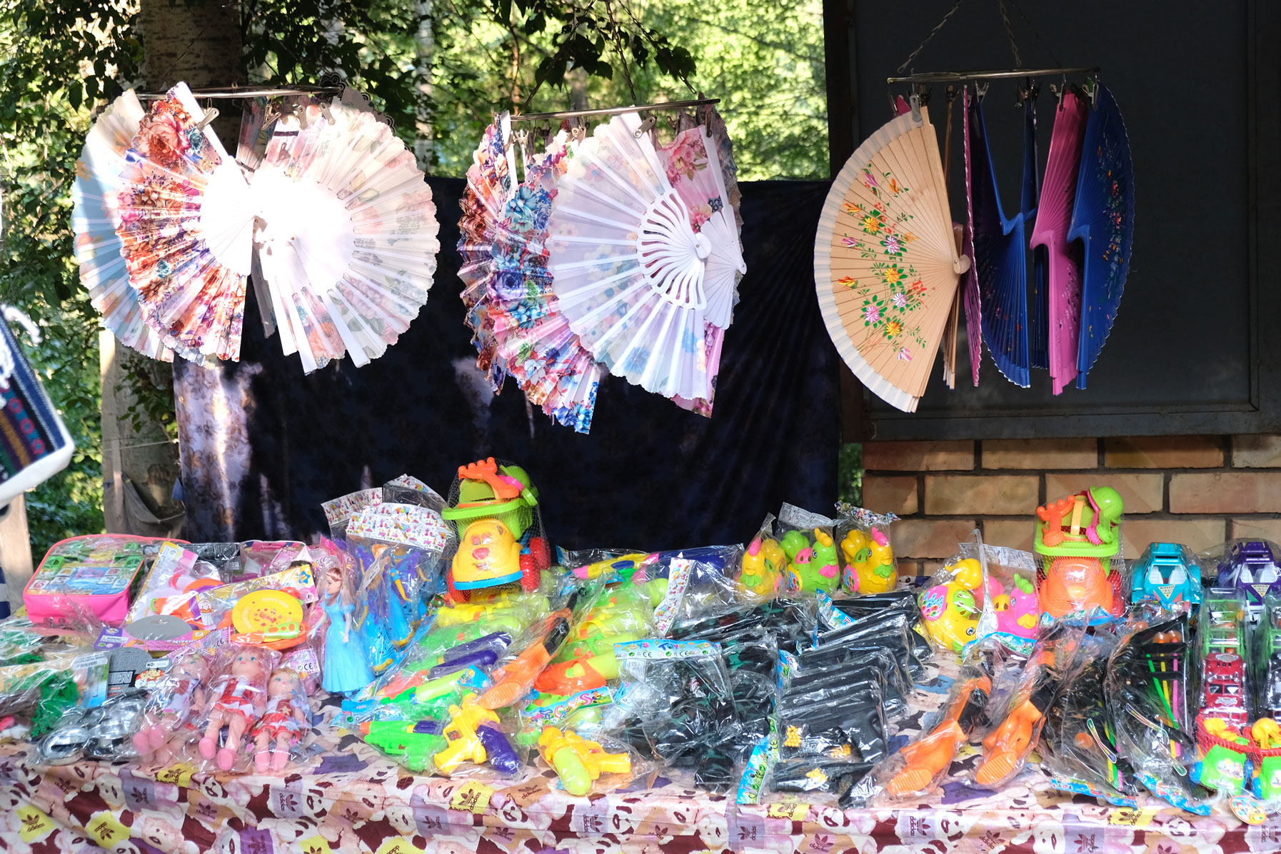 Fächer und Souvenire aus Plastik an einem Verkaufsstand.