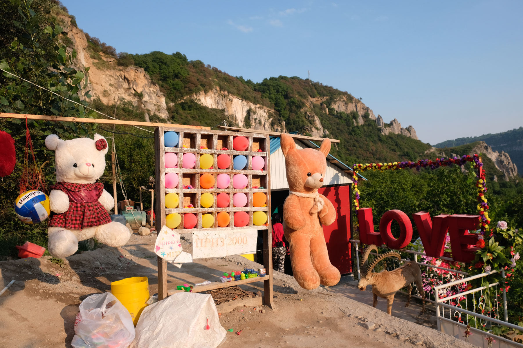 Überdimensionale Stofftiere und Luftballons in einem Holzregal.