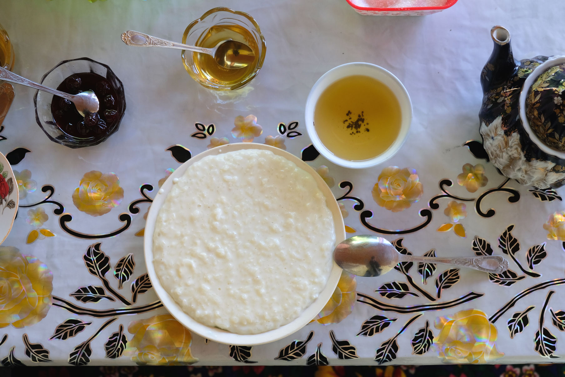 Milchreis, Tee und Honig auf einem Tisch.
