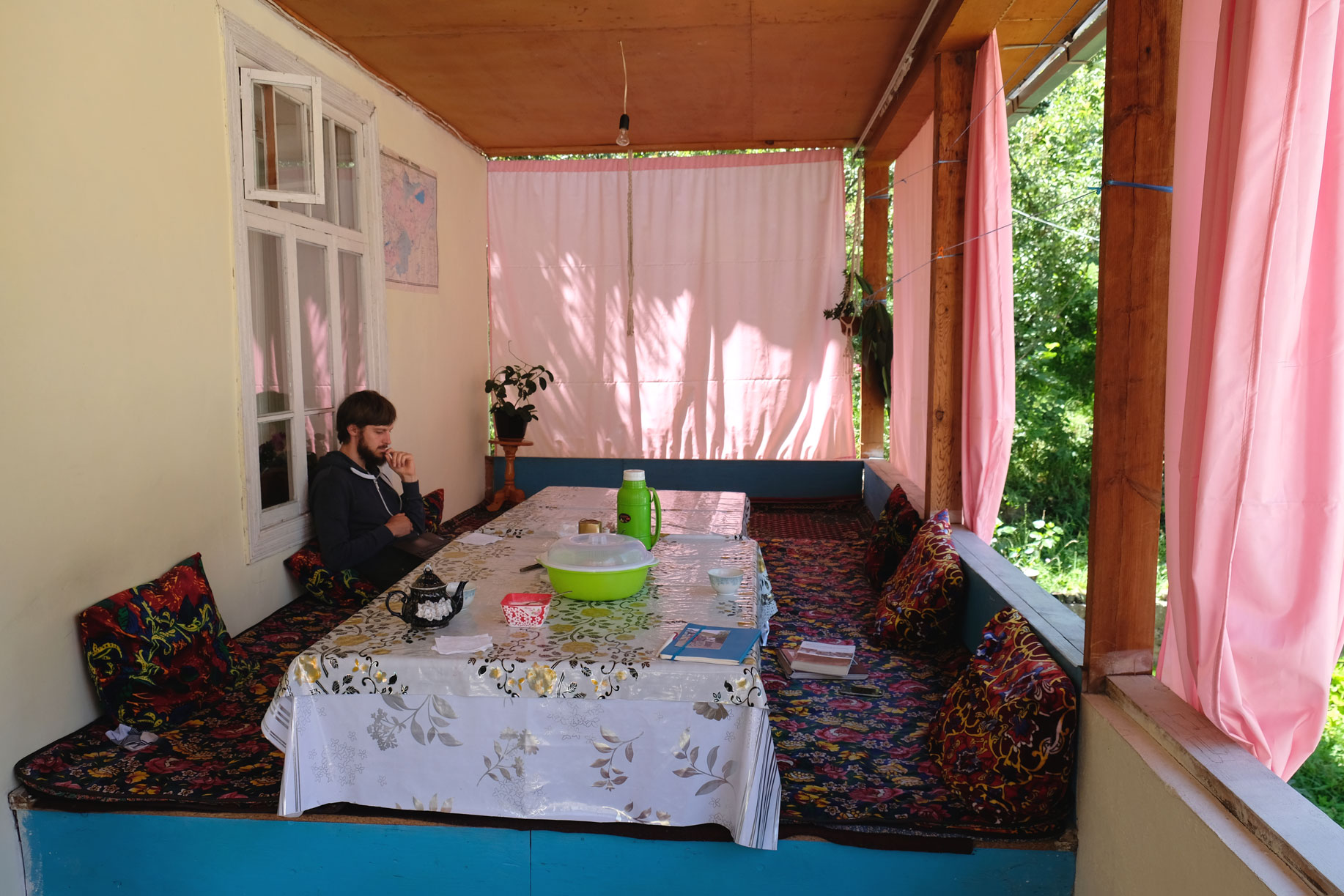 Sebastian sitzt am Tisch eines Homestays in Arslanbob.