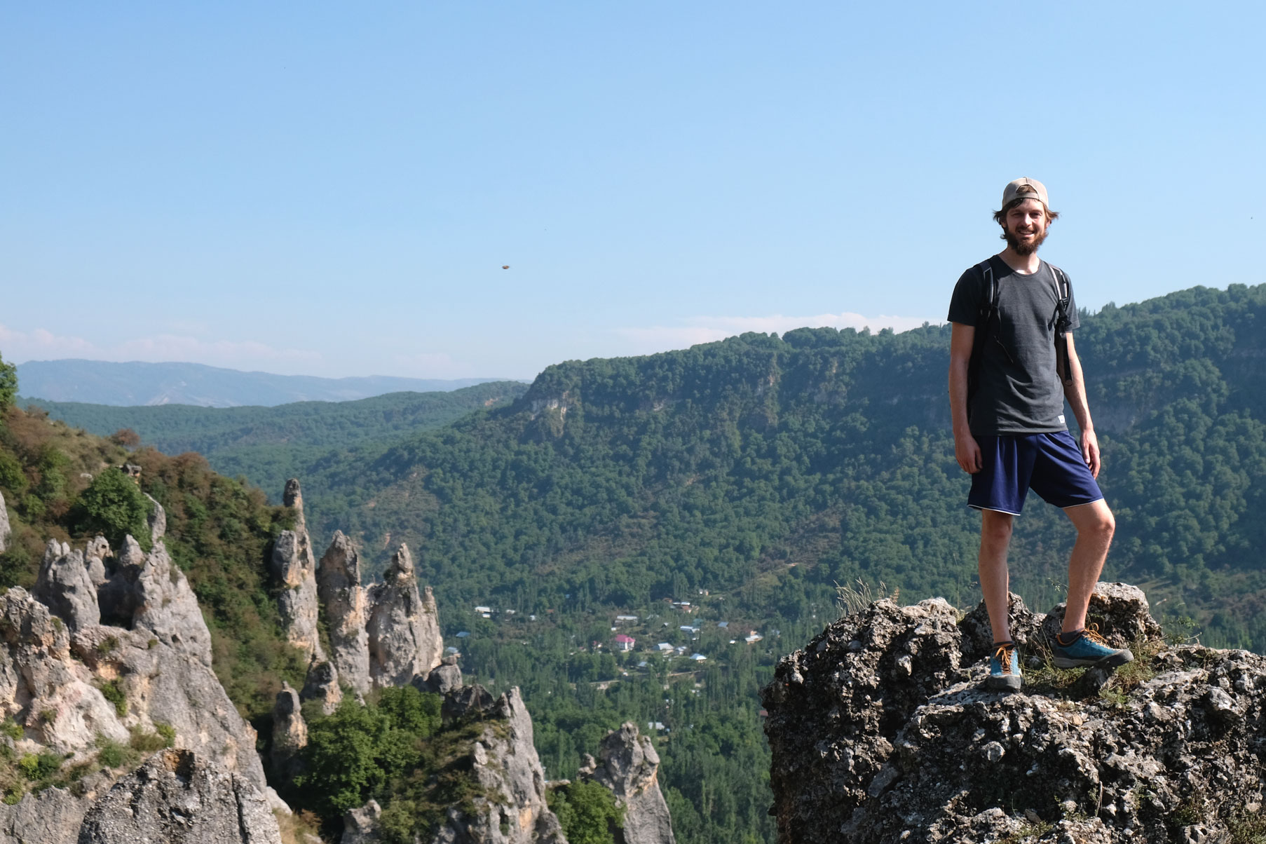 Sebastian steht auf einem Felsen in den Bergen.
