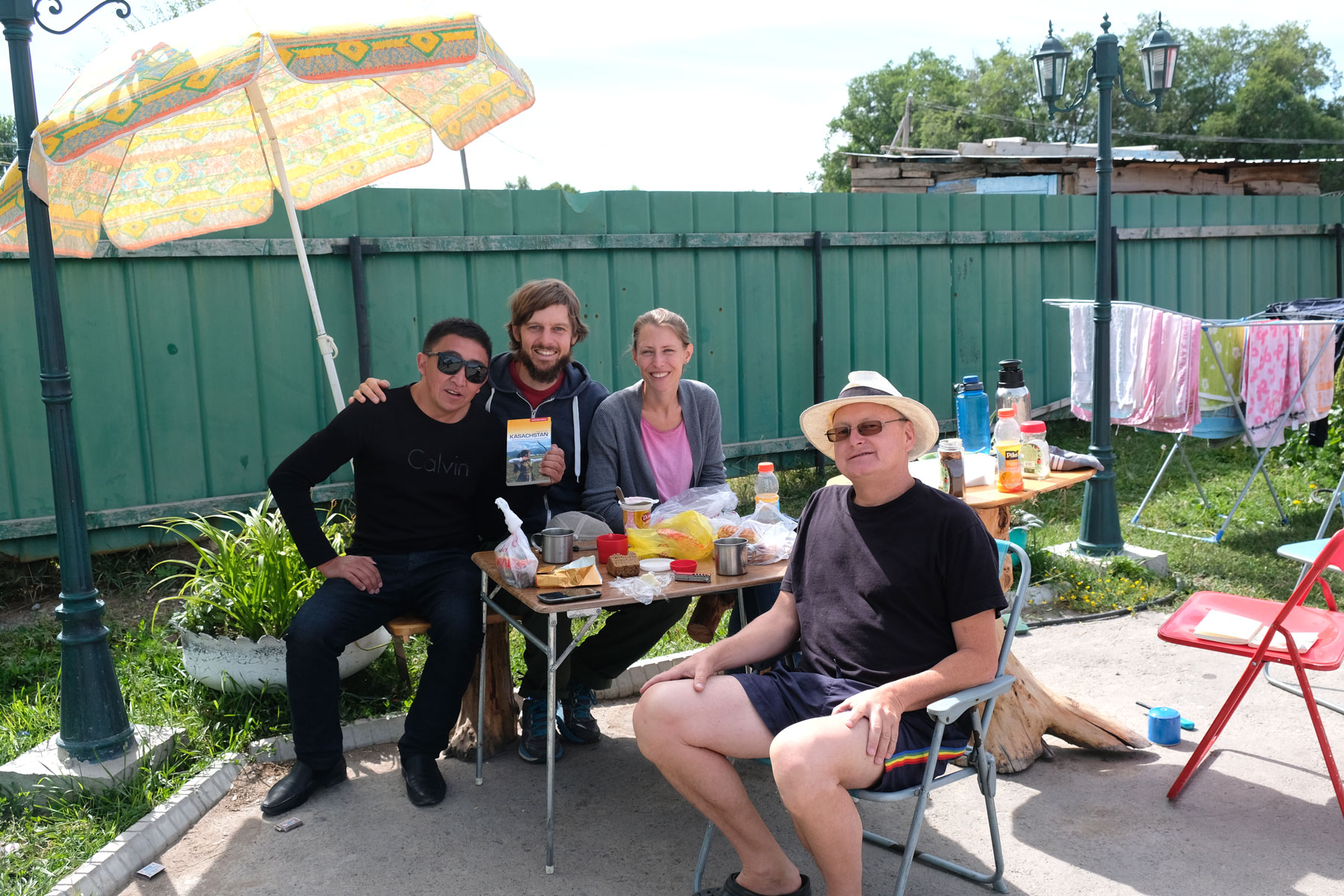Sebastian, Leo und Thomas sitzen mit einem Mann beim Frühstück.