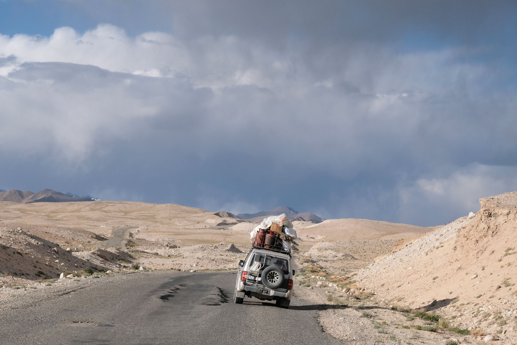 Ein hoch belandener Geländewagen und Spurrillen auf dem Pamir Highway.