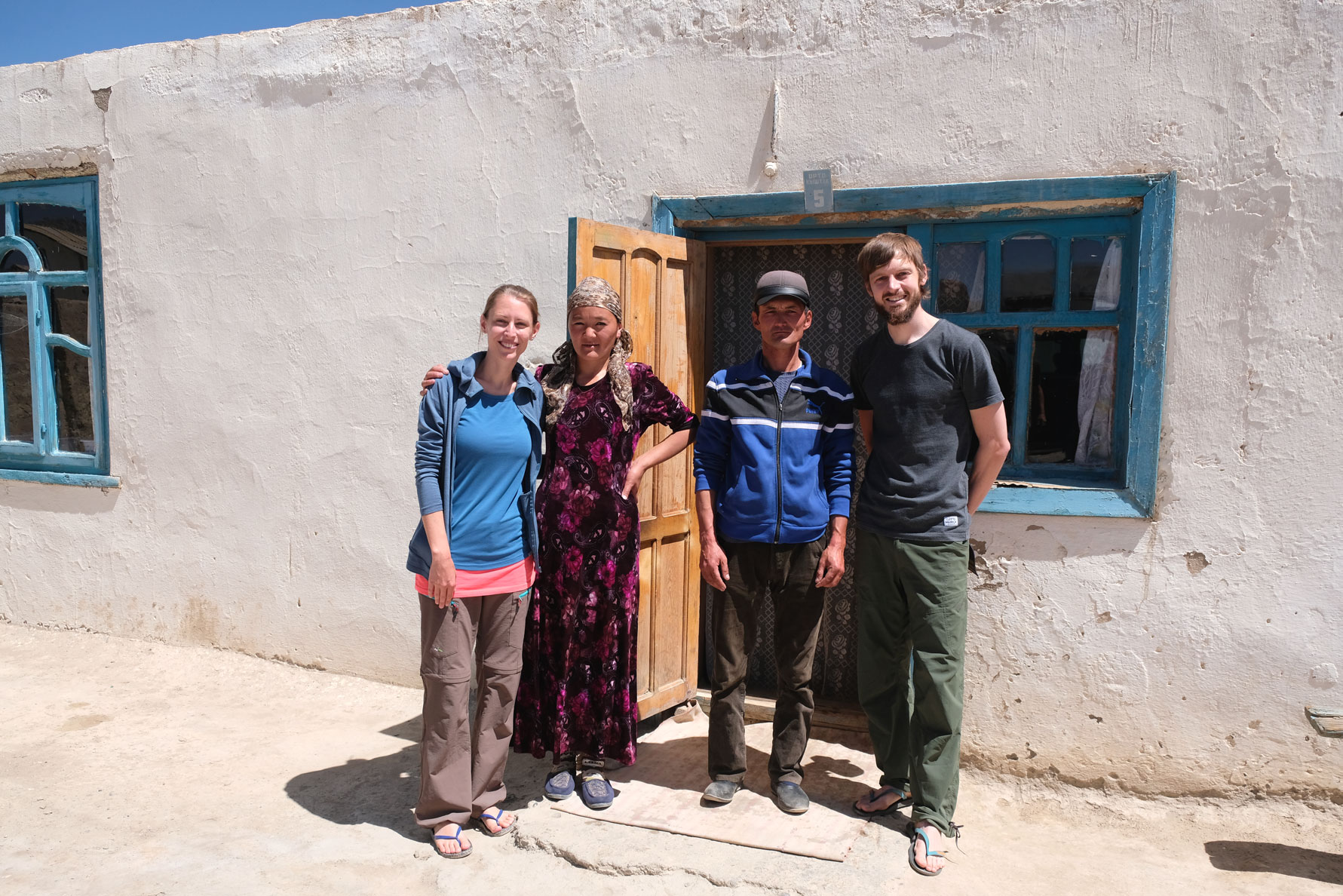 Leo und Sebastian mit zwei Personen vor einem Homestay in Rangkul im Pamirgebirge.