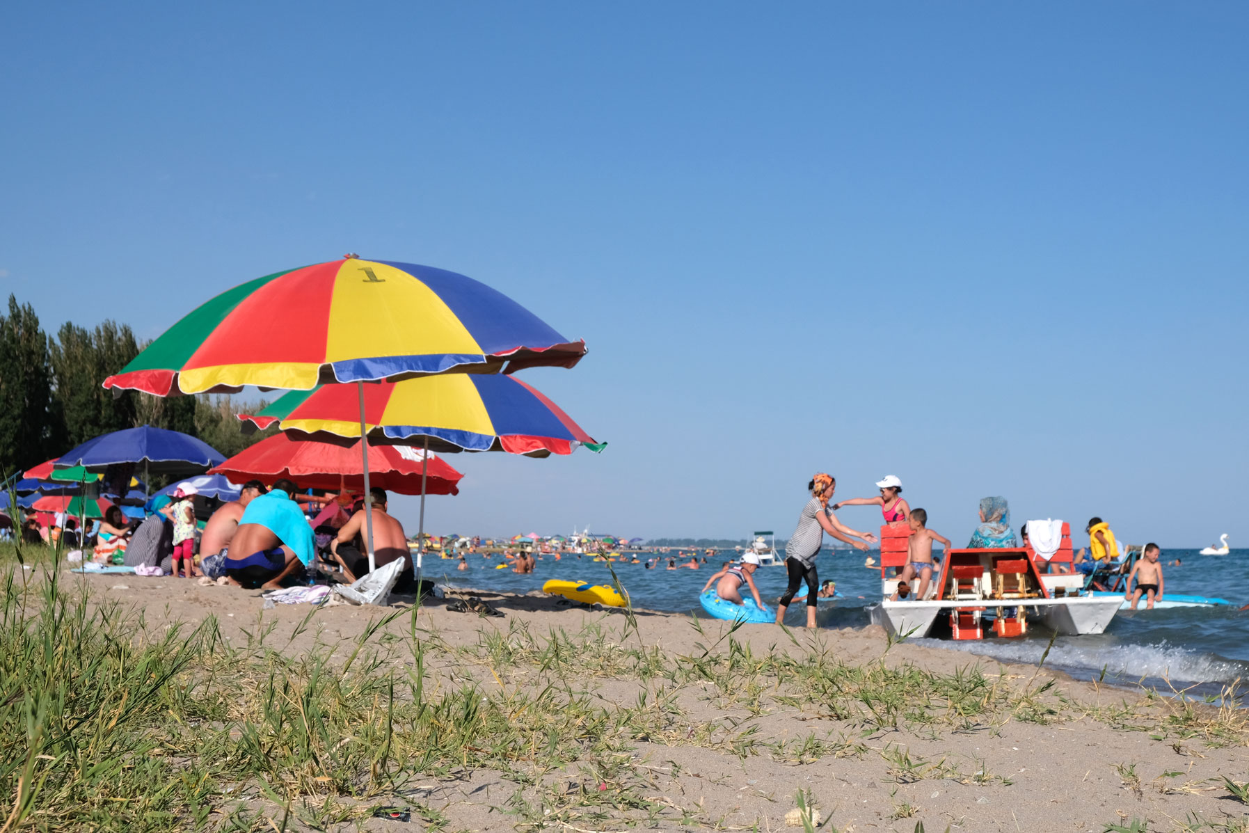 Sonnenschirme am Strand des Issyk-Kul Sees bei Tamchy.