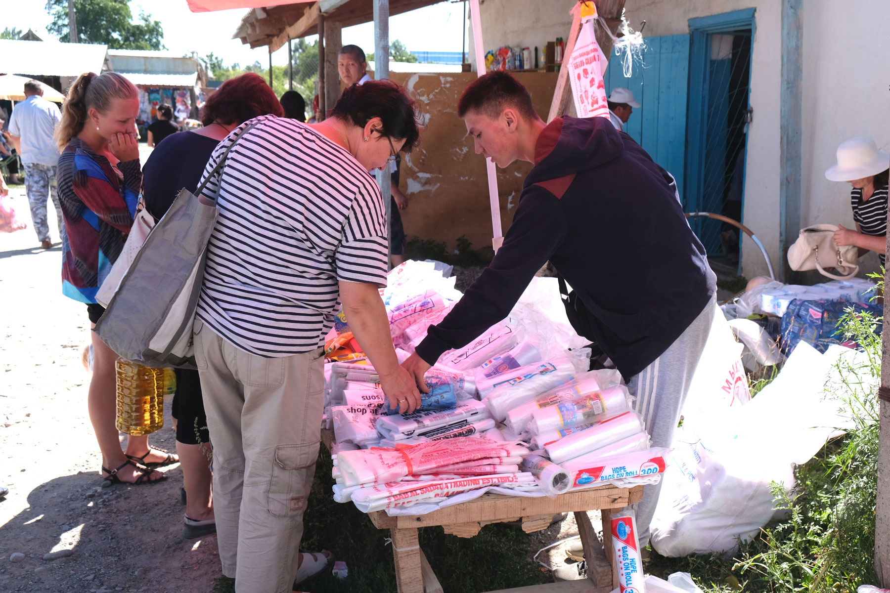 An einem Marktstand werden Plastiktüten verkauft.