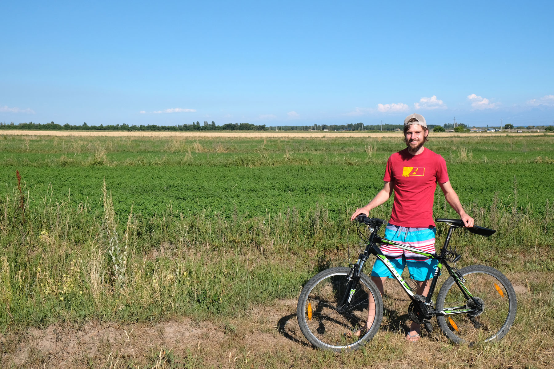 Sebastian neben einem Mountainbike auf einer Wiese.