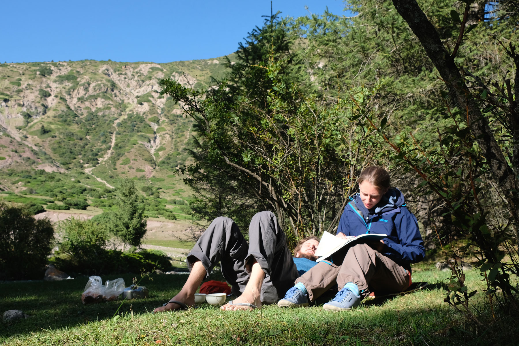 Sebastian und Leo liegen auf einer Wiese in der Sonne.