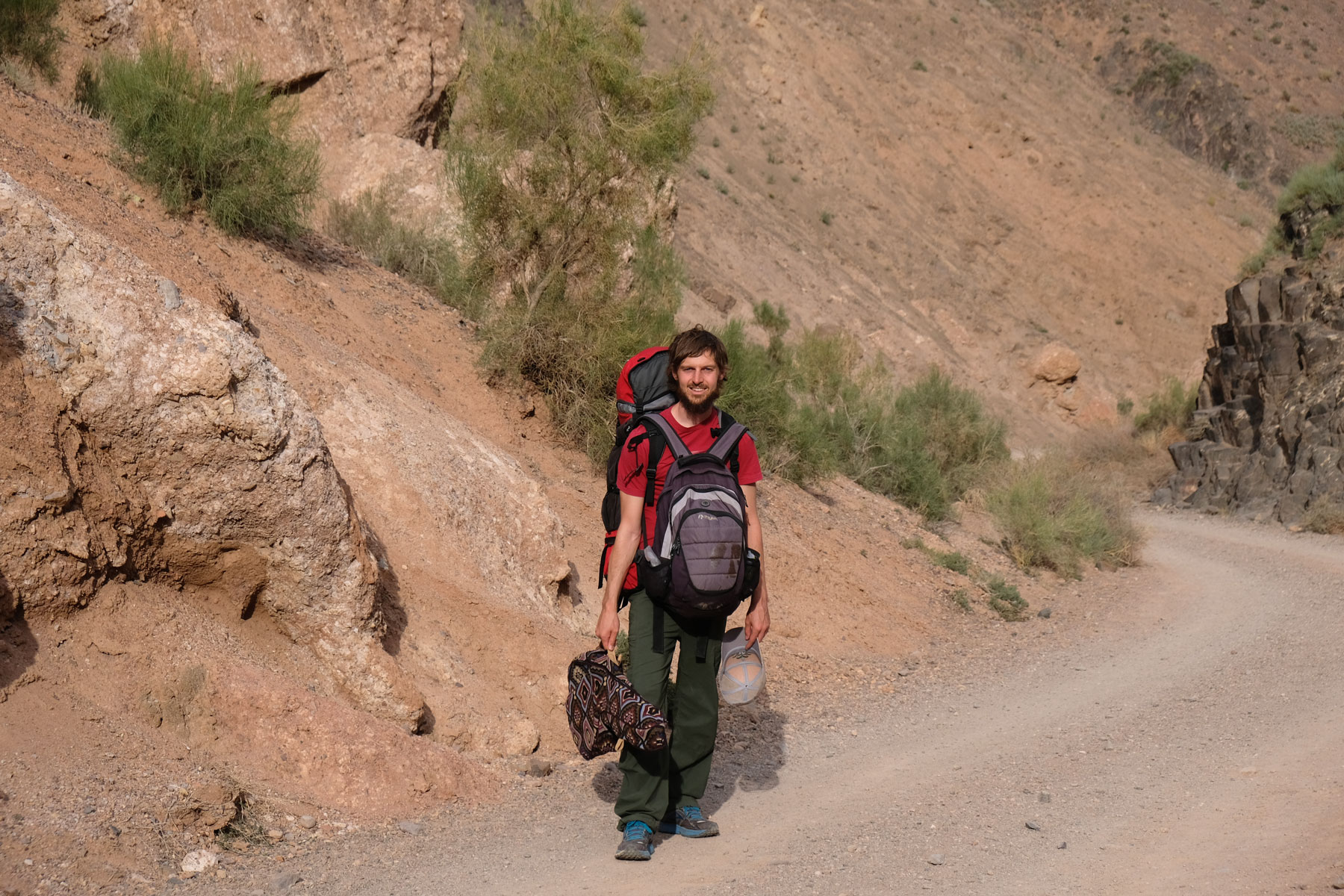 Sebastian steht mit Rucksack und Gitarre im Charyn Canyon.