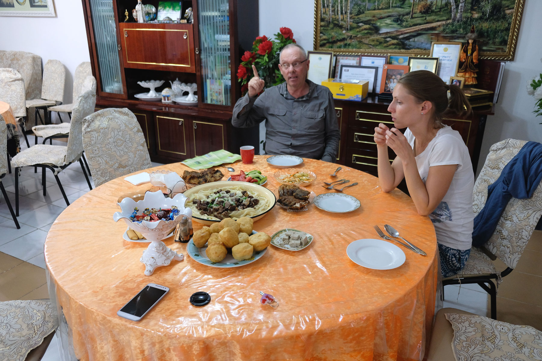 Leo sitzt gelangweilt mit einem Mann beim Abendessen.