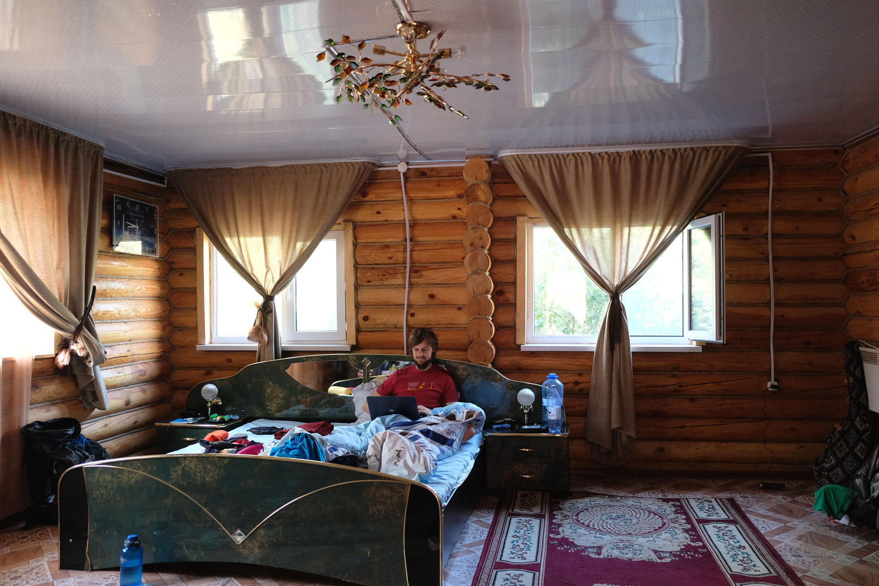 Sebastian sitzt im Bett in einer Holzhütte in Korgalzhyn.