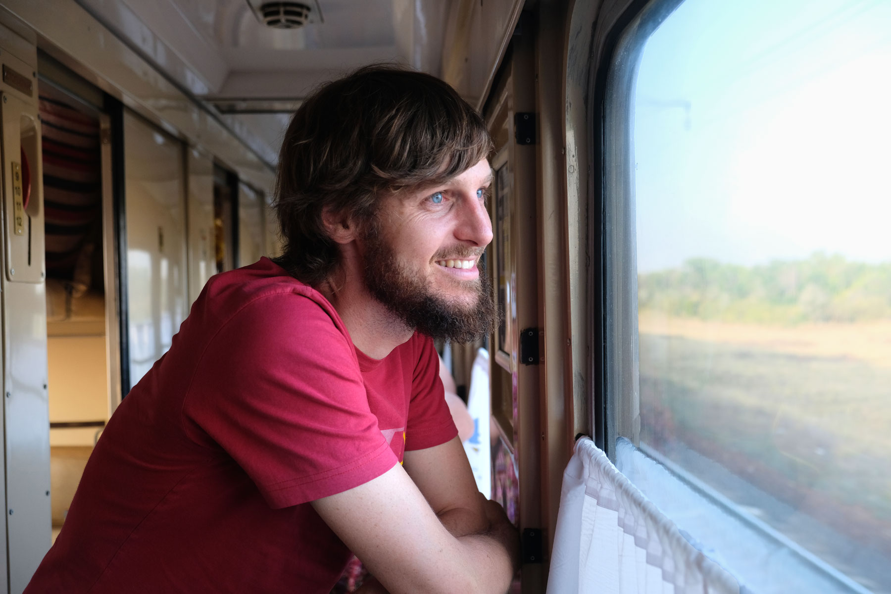 Sebastian schaut aus dem Fenster eines Zugs.